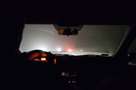 Foggy road. View from driving car at night.の写真素材