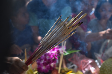 Incense sticks on joss stick pot are burning and smoke use for pay respect to the Buddha.