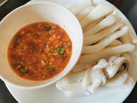Steamed squid with chili sauce on white plate. Thai food.の写真素材
