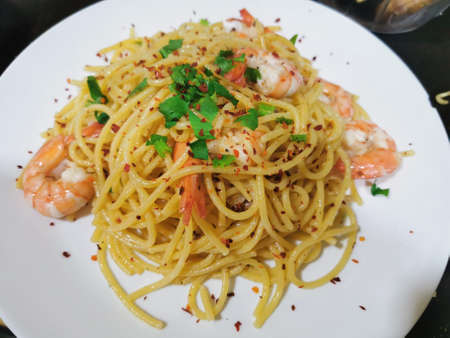 Spaghetti with shrimps and parsley on white plate.の写真素材