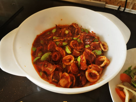 Stir fried squid with chili paste in white bowl on the tableの写真素材