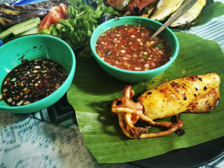 Grilled squid with chilli sauce on banana leaf, Thai foodの写真素材