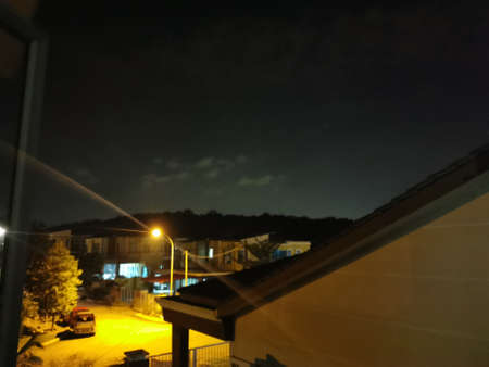 night view of the city from the window of a private house on a cloudy dayの写真素材