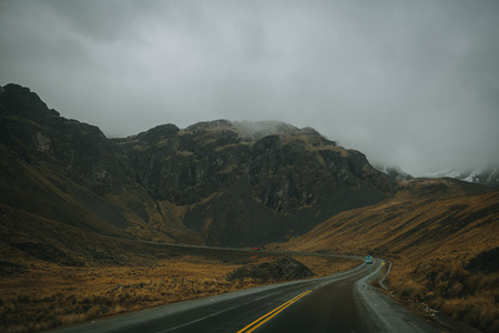 View of the Yungas Road or Death Road, Bolivia curving through rugged mountains on an overcast grey dayの写真素材
