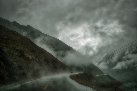 Low grey clouds in mountains and wet asphalt of Yungas road after rain. Bolivia, South Americaの写真素材