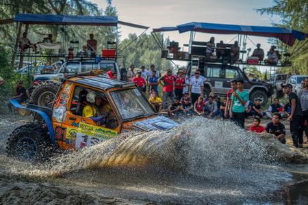 KELANTAN, MALAYSIA - NOVEMBER 2018 : Spectators watching the Rainforest Challenge, Kelantan, Malaysia as a 4x4 vehicle negotiates a water hazard in a cloud of sprayのeditorial素材