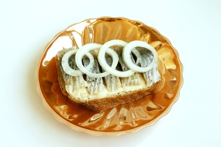 Food. Delicious sandwich with salted fish and onions on a saucerの写真素材