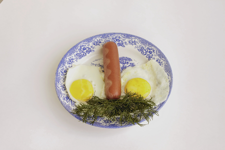 Food. Tasty breakfast. Fried eggs and sausage with fennel in a plateの写真素材