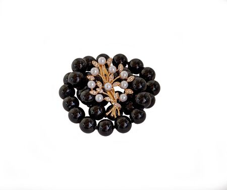 Black pearls and brooch on a white backgroundの写真素材