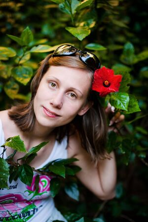 Beautiful woman in the garden with red flowerの写真素材