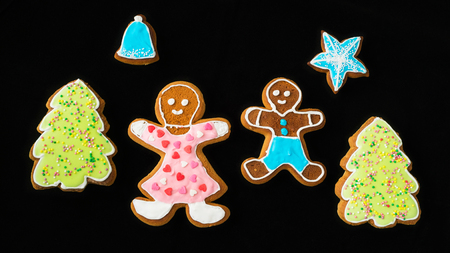 Gingerbread man, mother son and fir trees on black velvet in christmas