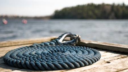 Coastal dock on a rocky area with blue nautical sailing rope for boats and yachts.の写真素材