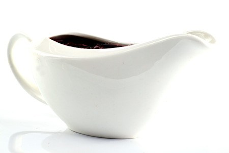 Creamy sauce in the white sauceboat isolated on whiteの写真素材