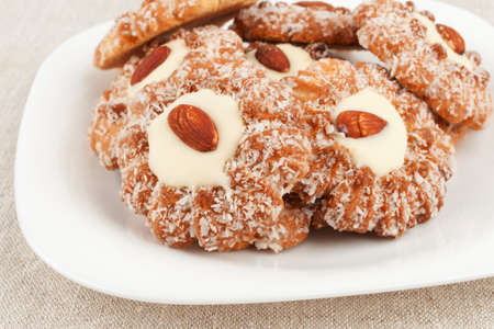 Biscuits with almonds on the edge of a white porcelain dishの写真素材