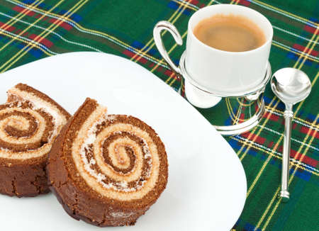 Two chocolate cake roll on a plate with a coffee cupの写真素材