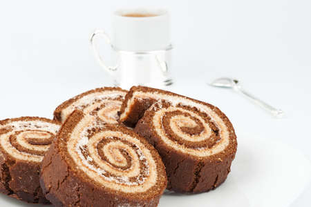 Four chocolate roll on a plate with a cup of coffee closeupの写真素材