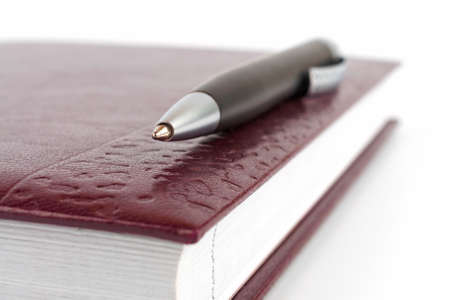 Closeup black ballpoint pen lying on the leather cover diaryの写真素材