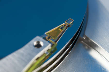 Hard disk read head closeup on a blue backgroundの写真素材