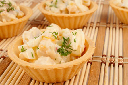 Tartlets with salad on a bamboo napkinの写真素材