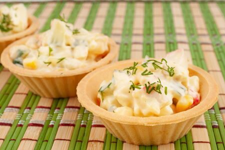 Tartlets with salad on a bamboo napkinの写真素材