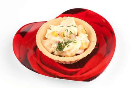 Tartlet with salad on a red plate on white backgroundの写真素材