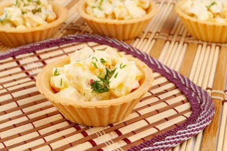 Tartlets with salad on a bamboo napkinの写真素材
