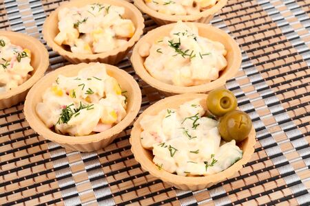 Tartlets with salad on a bamboo napkinの写真素材