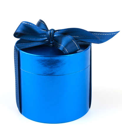 Round gift box with a blue satin bow on a white backgroundの写真素材