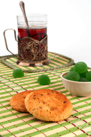 Glass of tea in the glass-holder and cookies in the foregroundの写真素材