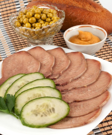 Slices of boiled beef tongue with green peasの写真素材