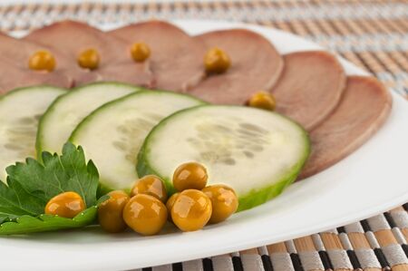 Slices of boiled beef tongue with green peasの写真素材
