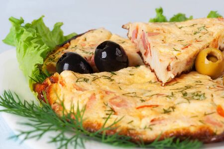 Slices of omelette with colorful olivesの写真素材