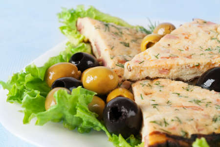Slices of omelette with colorful olivesの写真素材