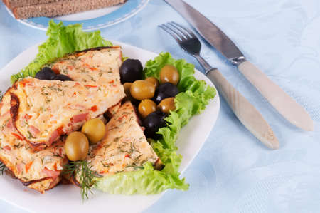 Slices of omelette on a plate  Against the background of a blue tableclothの写真素材