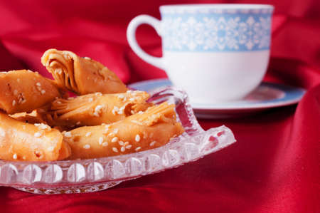 Puff pastry on a crystal blue saucer in front of a tea cup 