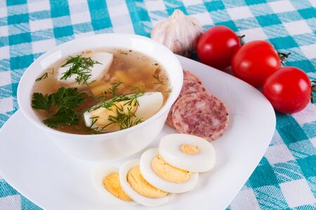 Vegetable soup decorated with slices of sausage and egg  On colored tableclothsの写真素材