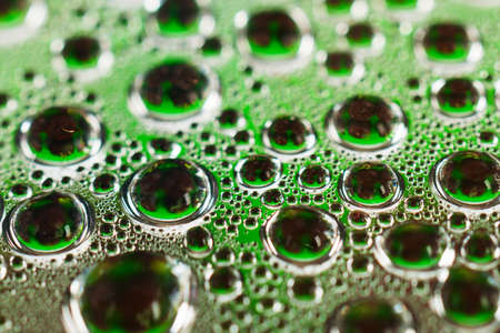 Water drops on green transparent glass close upの写真素材