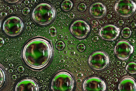 Water drops on a dark green glass close upの写真素材