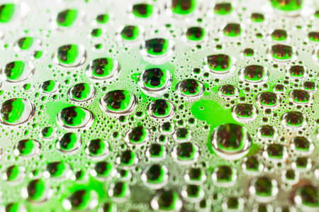 Water drops on green transparent glass close upの写真素材