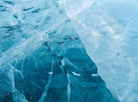 Network of cracks in thick solid layer of ice of a frozen riverの写真素材