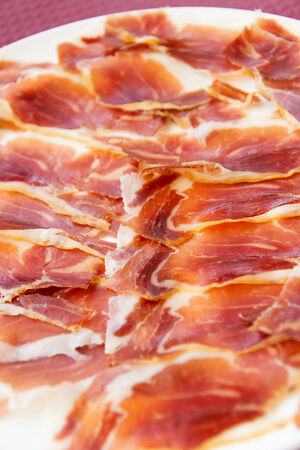 Slicing jamon on a white plate の写真素材