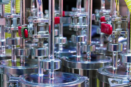 A lot of ball valves made of stainless steel. Steel tubes and cylinders.
