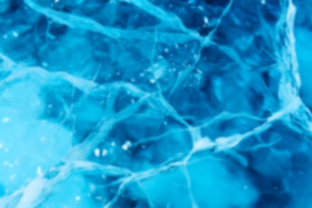 Abstract Blue river ice with large cracks. Deep blur.