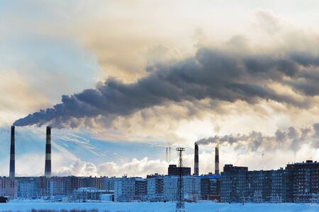 Smokestacks polluting the air over the city. Winter landscape.の写真素材