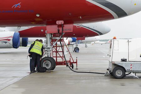 MOSCOW, RUSSIA - MAY 19, 2016: Aircraft  Tupolev-204 Red Wings airline in the parking lot of the international airport Domodedovo. The service engineer carry out work on inspection of the landing gear.のeditorial素材