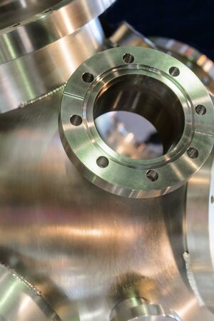 Industrial background, heavy metal housing with welded metal flanges. Shallow depth of field.