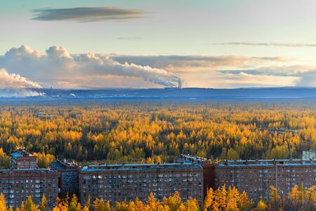 Smokestack smokestacks that pollute the atmosphere. Ecological catastrophy. Polar tundra, deep autumn. Sunset, bad lighting conditions.の写真素材