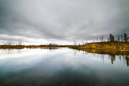 Lake in tundra in the Taimyr Peninsula, the Arctic Circle, Norilsk city. Deep autumn. Cloudy day,...