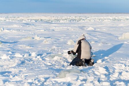 The photographer is photographing with telephoto lens in the Arctic ice.