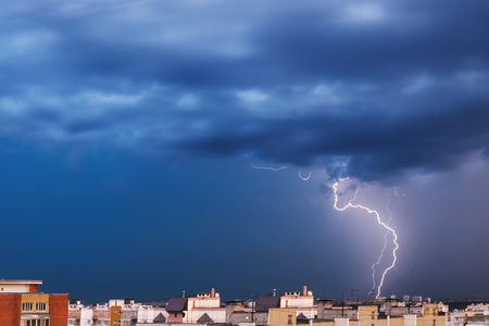 Storm clouds, heavy rain. Thunderstorm and lightning over the night city.